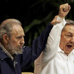 FILE - In this April 19, 2011 file photo, Fidel Castro, left, raises his brother's hand, Cuba's President Raul Castro, center, as they sing the anthem of international socialism during the 6th Communist Party Congress in Havana, Cuba. Cuban President Raul Castro has announced the death of his brother Fidel Castro at age 90 on Cuban state media on Friday, Nov. 25, 2016. 