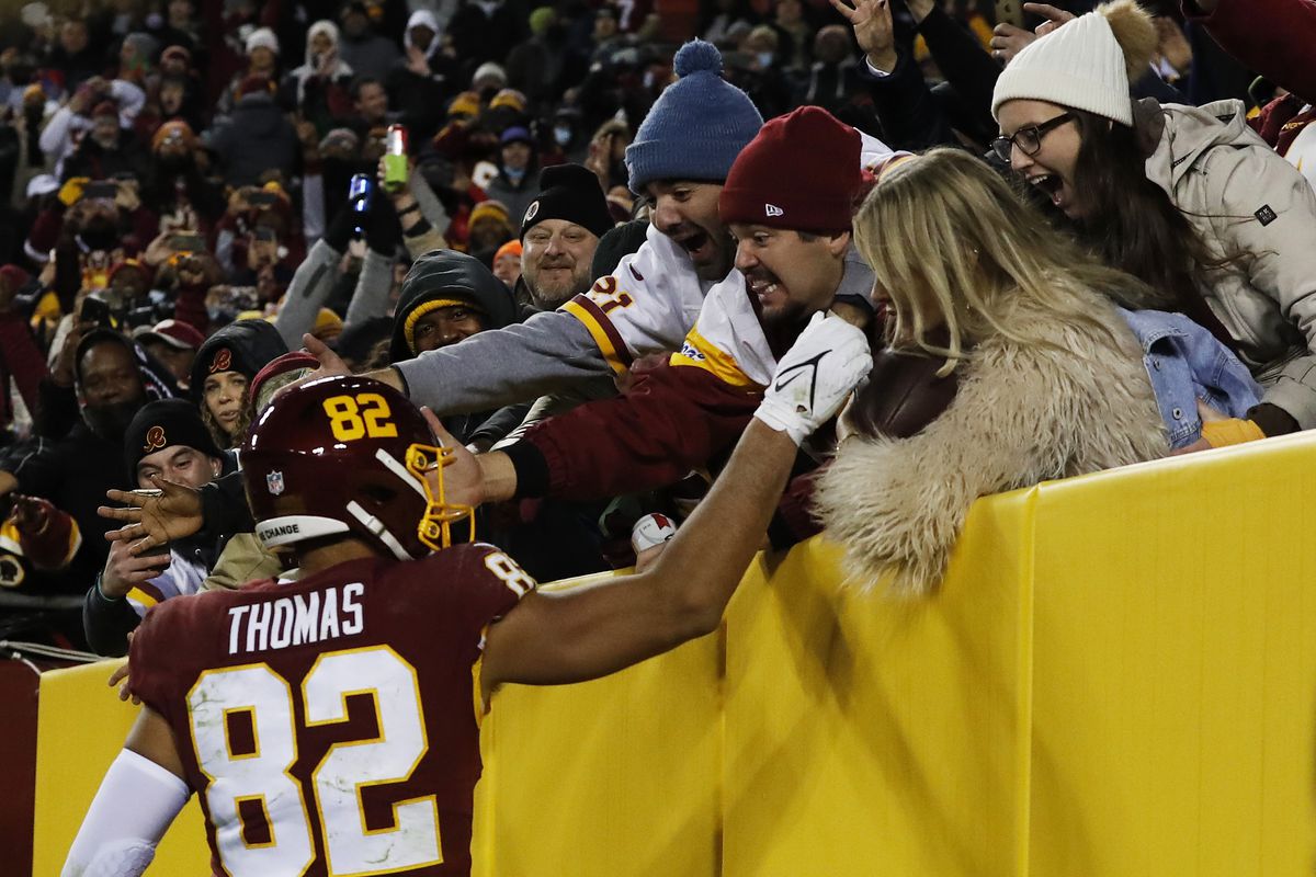 Logan Thomas #82 of the Washington Football Team celebrates his touchdown against the Seattle Seahawks with fans during the fourth quarter at FedExField on November 29, 2021 in Landover, Maryland. After review, it was concluded that Thomas’ knee was short of the goal line and the touchdown was called back.