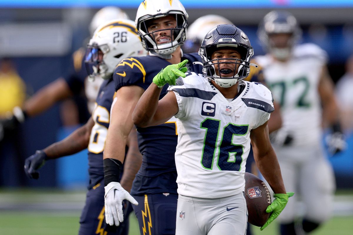 Tyler Lockett #16 of the Seattle Seahawks celebrates his catch for a first down in front of Joshua Onujiogu #49 of the Seattle Seahawks during a 37-23 win at SoFi Stadium on October 23, 2022 in Inglewood, California.