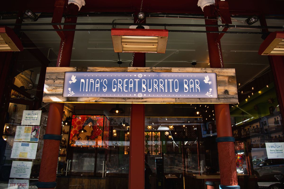 An exterior of a restaurant with a blue and white sign spelling out the title of the restaurant.