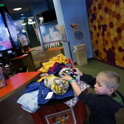 Spencer Cuthbert, 4, of West Jordan, places new blankets into a bin during the third annual Share the Warmth event at Discovery Gateway on Thursday, Feb. 12, 2015. Guests were invited to bring in a new or gently used blanket or coat for families at the Road Home in exchange for one free admission per donation.
