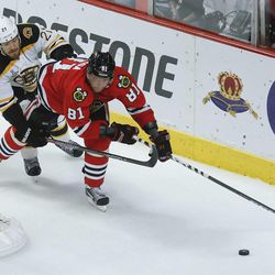 Chicago Blackhawks right wing Marian Hossa (81) looks to wrap the puck around the goal against Boston Bruins defenseman Andrew Ference (21) in the second period during Game 5 of the NHL hockey Stanley Cup Finals, Saturday, June 22, 2013, in Chicago. (AP Photo/Charles Rex Arbogast)