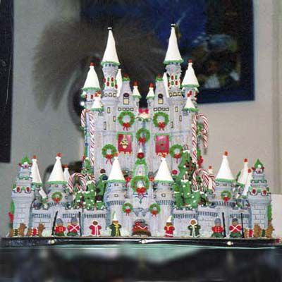 Detailed white gingerbread castle decorated with green wreaths made of icing. 