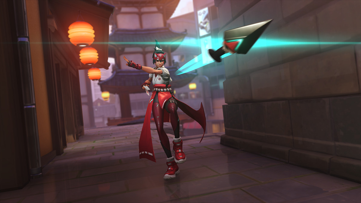 Kiriko, a thin woman with a fox hat, tosses a kunai knife toward the camera in Overwatch 2