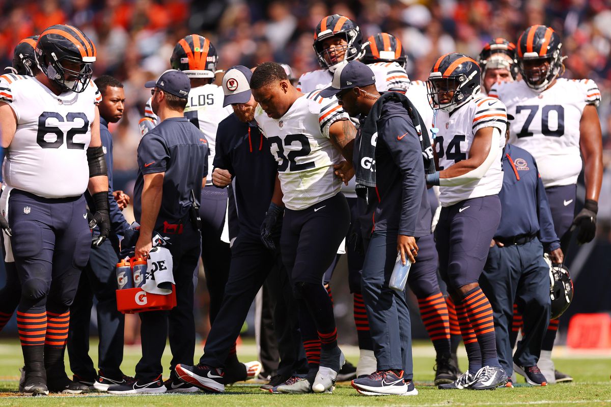 David Montgomery #32 of the Chicago Bears is helped off the field after being injured against the Houston Texans during the first quarter at Soldier Field on September 25, 2022 in Chicago, Illinois.