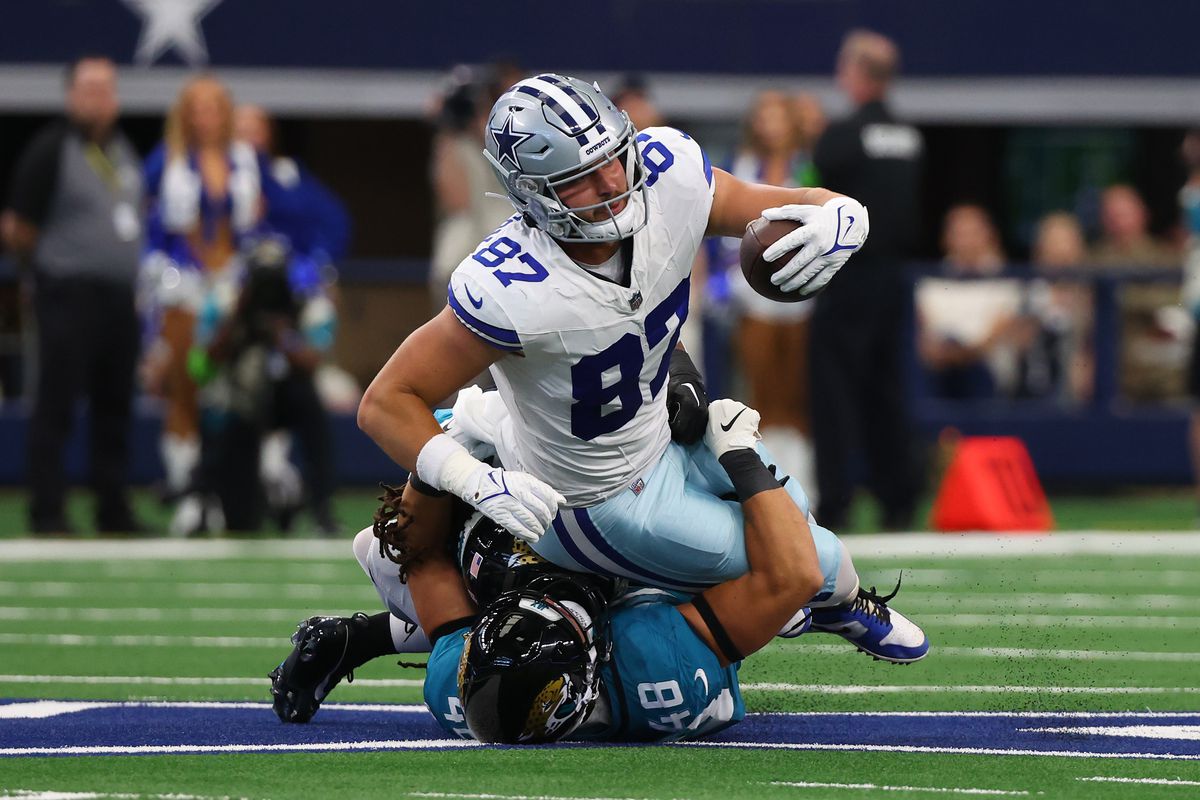 Jake Ferguson of the Dallas Cowboys is tackled by Chad Muma of the Jacksonville Jaguars in a preseason game at AT&amp;T Stadium on August 12, 2023 in Arlington, Texas.