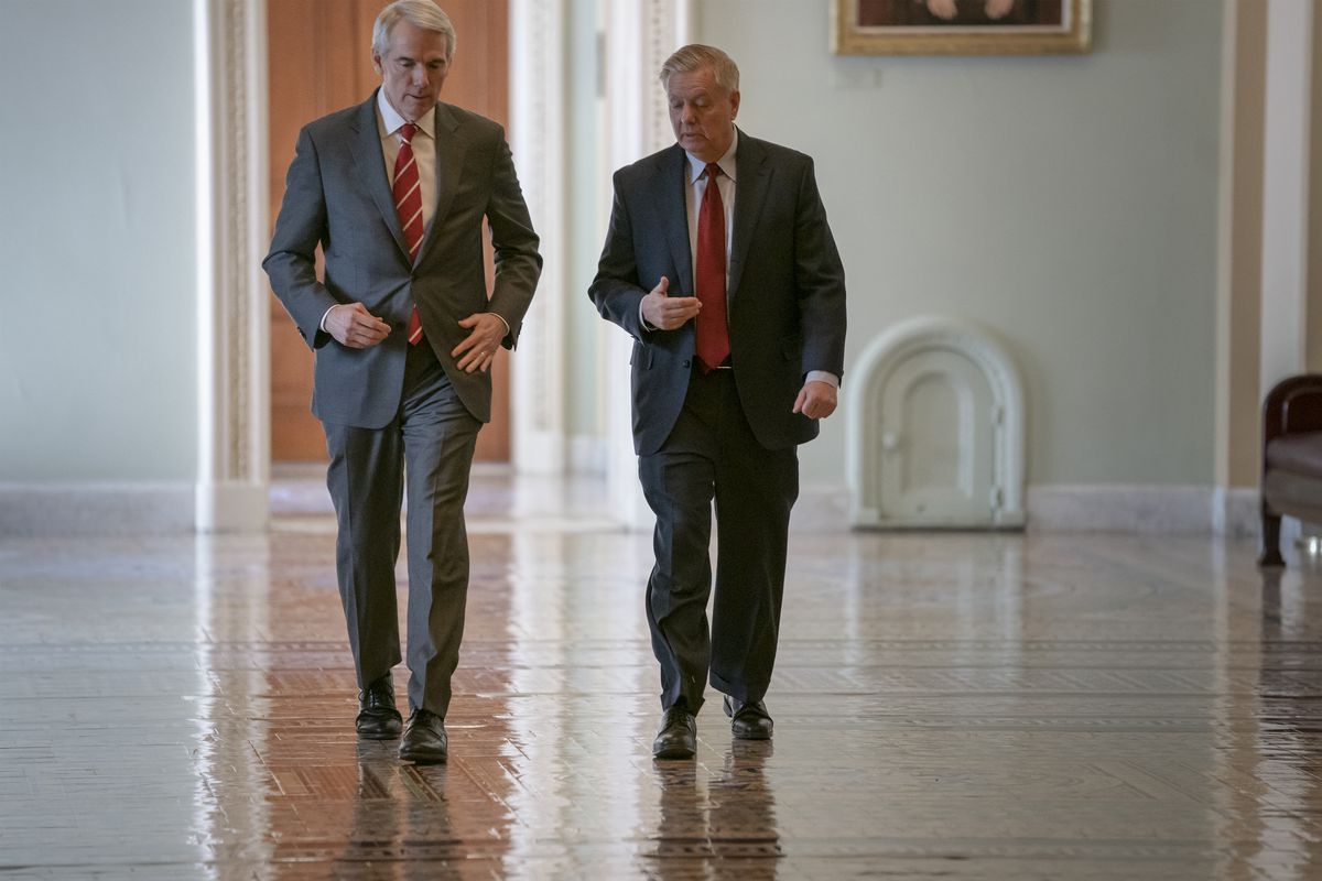 Sen. Rob Portman, R-Ohio, left, and Senate Judiciary Committee Chairman Lindsey Graham, R-S.C., walk to a meeting as an 11th-hour Republican rescue mission to keep President Donald Trump from a Senate defeat on his signature issue of building barriers alo