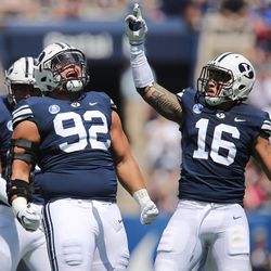 Brigham Young Cougars defensive lineman Handsome Tanielu (92) and Brigham Young Cougars defensive back Gavin Fowler (16) celebrate a good defensive stop against the Portland State Vikings in Provo on Saturday, Aug. 26, 2017. BYU won 20-6.