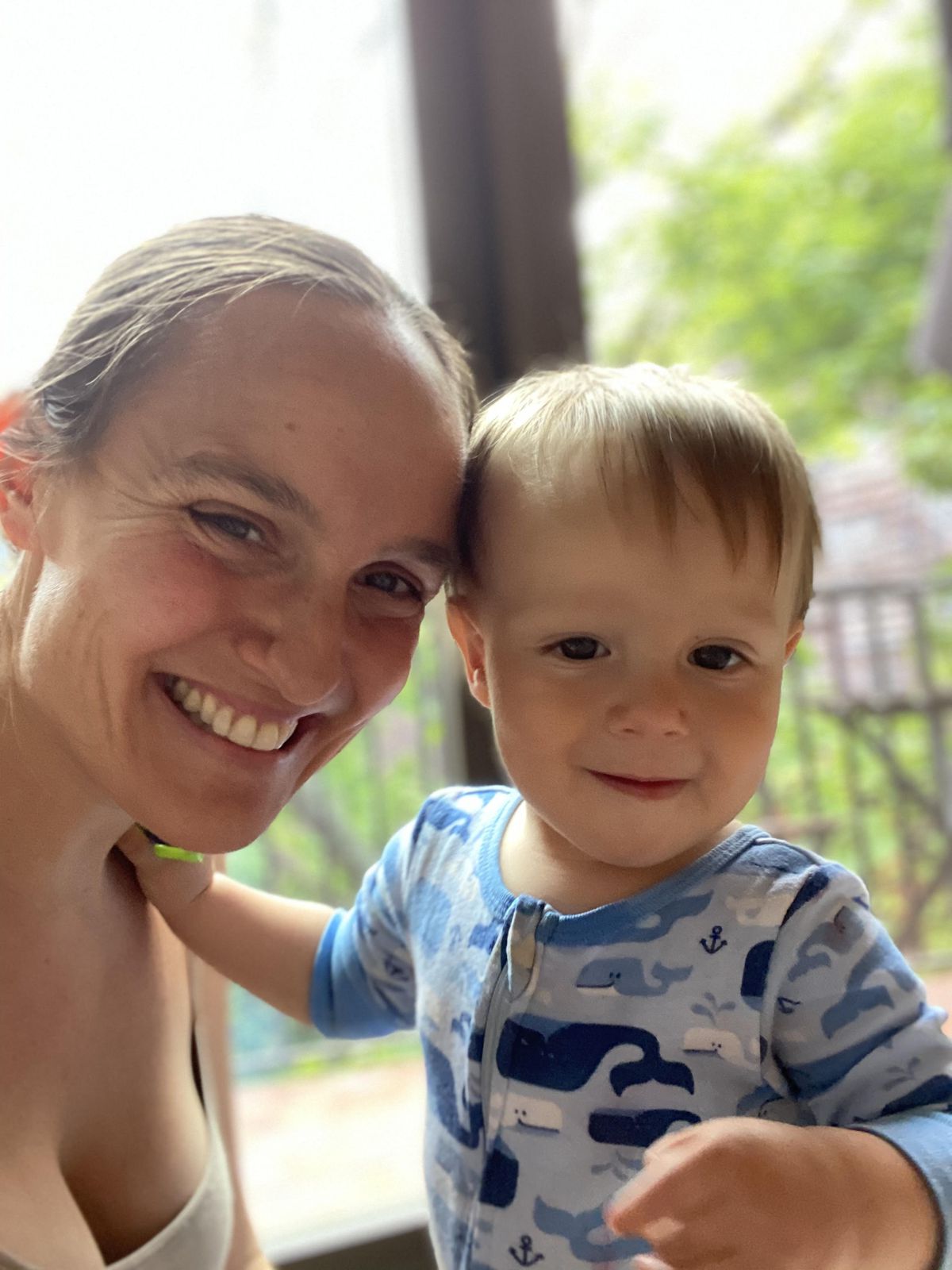A photo of Anne Hanger with her toddler son, posing in front of a window.