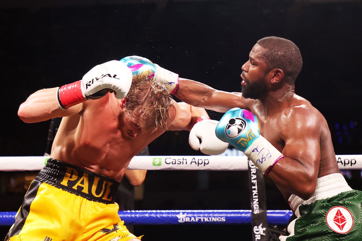 Floyd Mayweather exchanges blows with Logan Paul (yellow shorts) during their contracted exhibition boxing match at Hard Rock Stadium on June 06, 2021 in Miami Gardens, Florida.