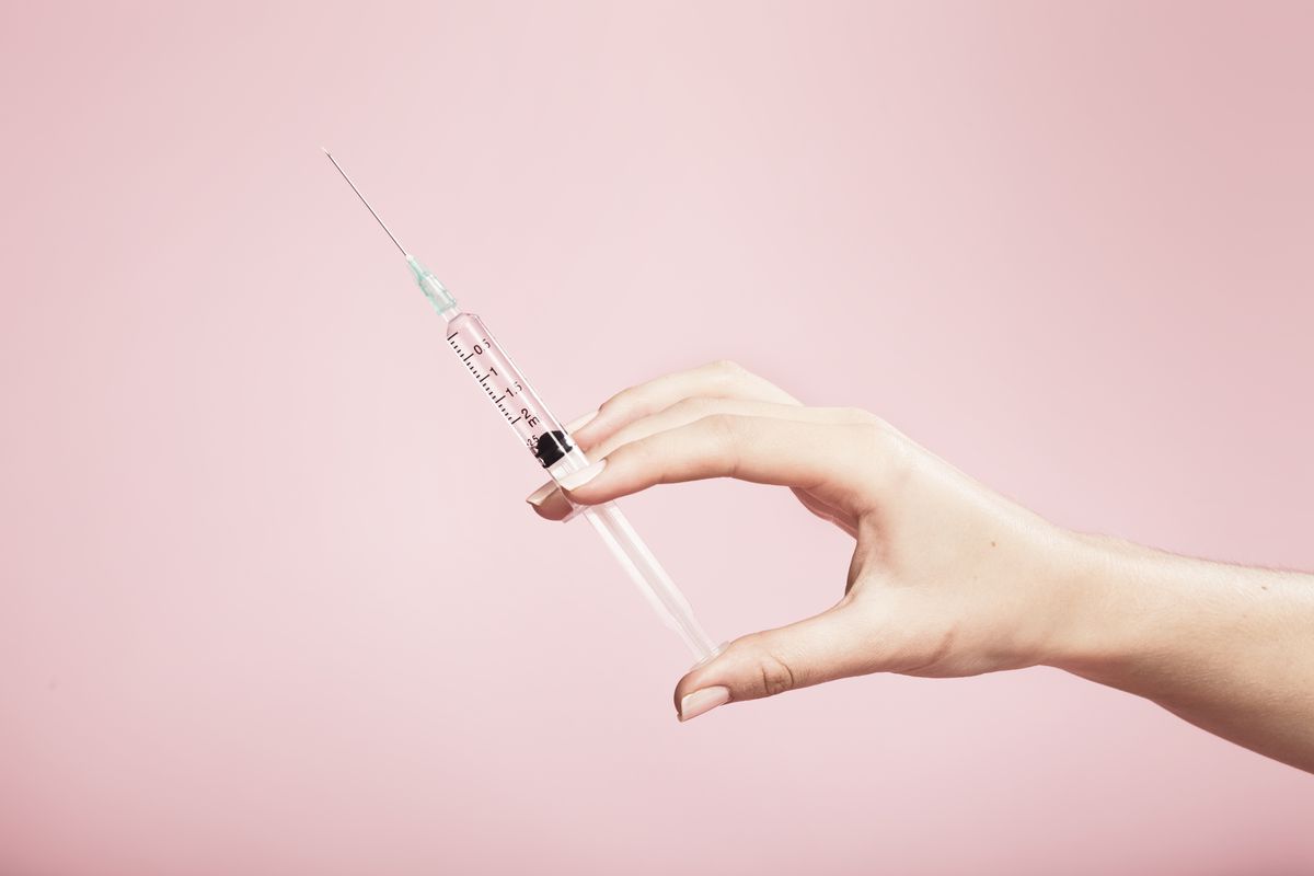 Woman’s hand holding a syringe
