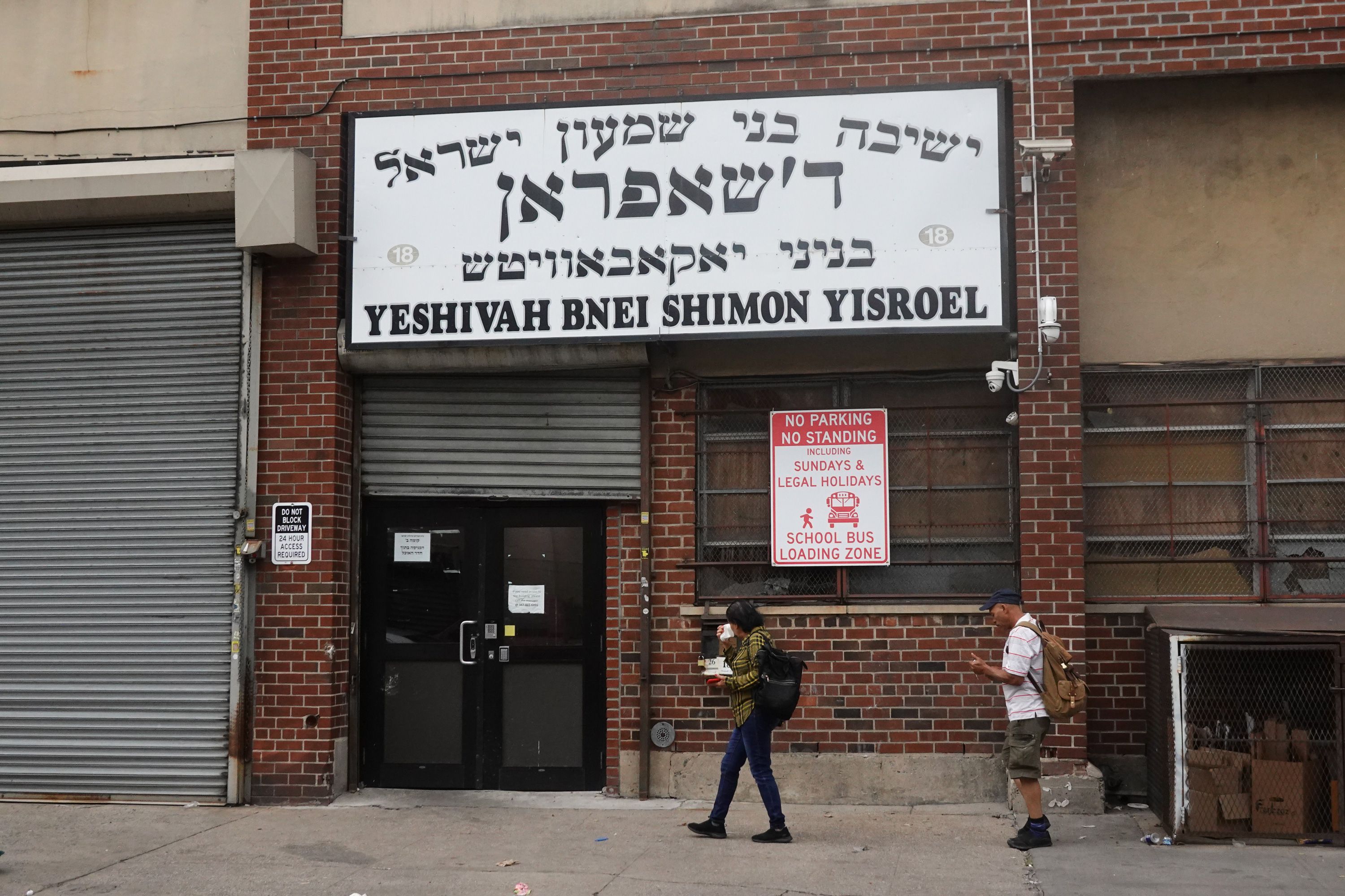Pedestrians walk by a Williamsburg industrial building housing Yeshiva Bnei Shimon Yisroel.