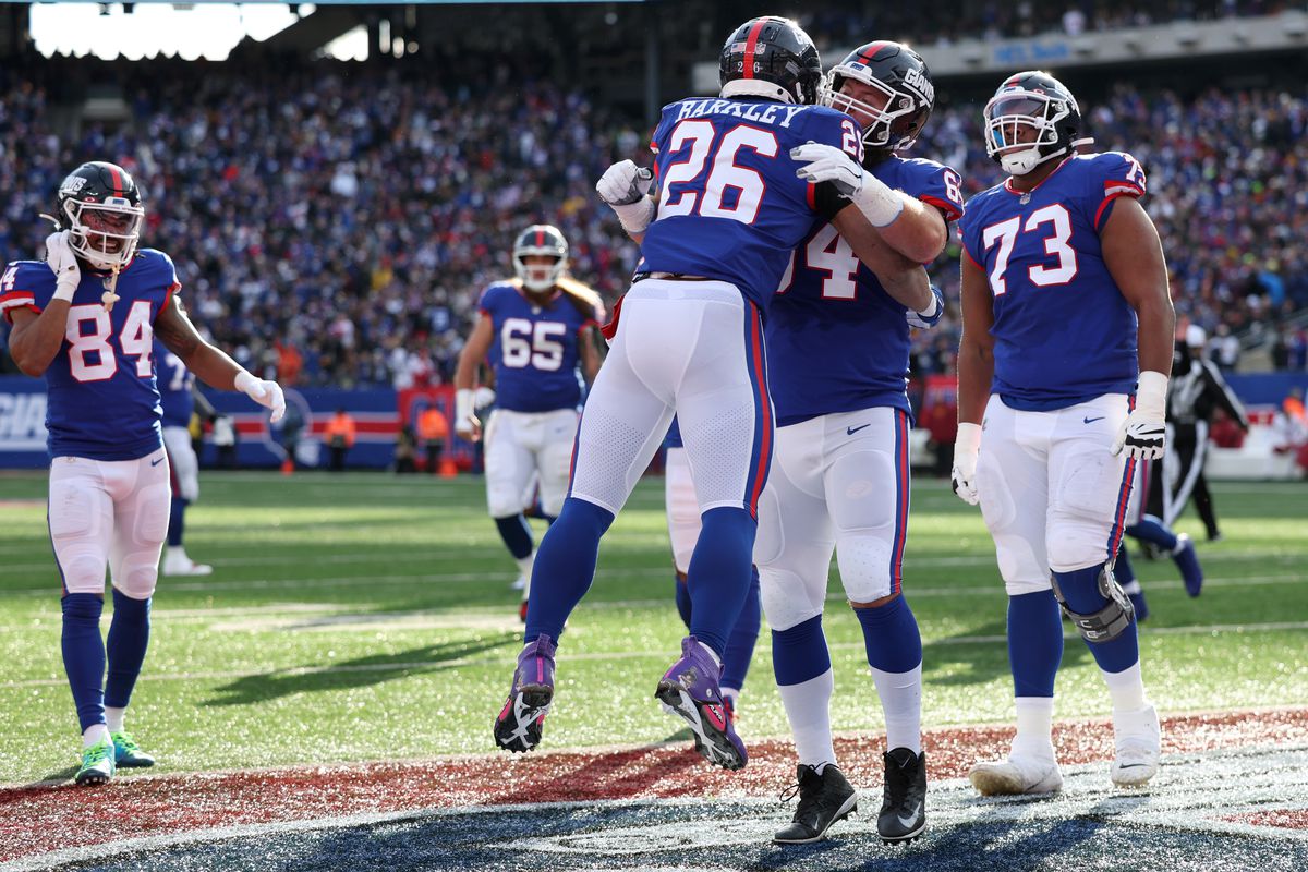 Saquon Barkley #26 of the New York Giants celebrates with teammates after scoring a touchdown in the second quarter of a game against the Washington Commanders at MetLife Stadium on December 04, 2022 in East Rutherford, New Jersey.