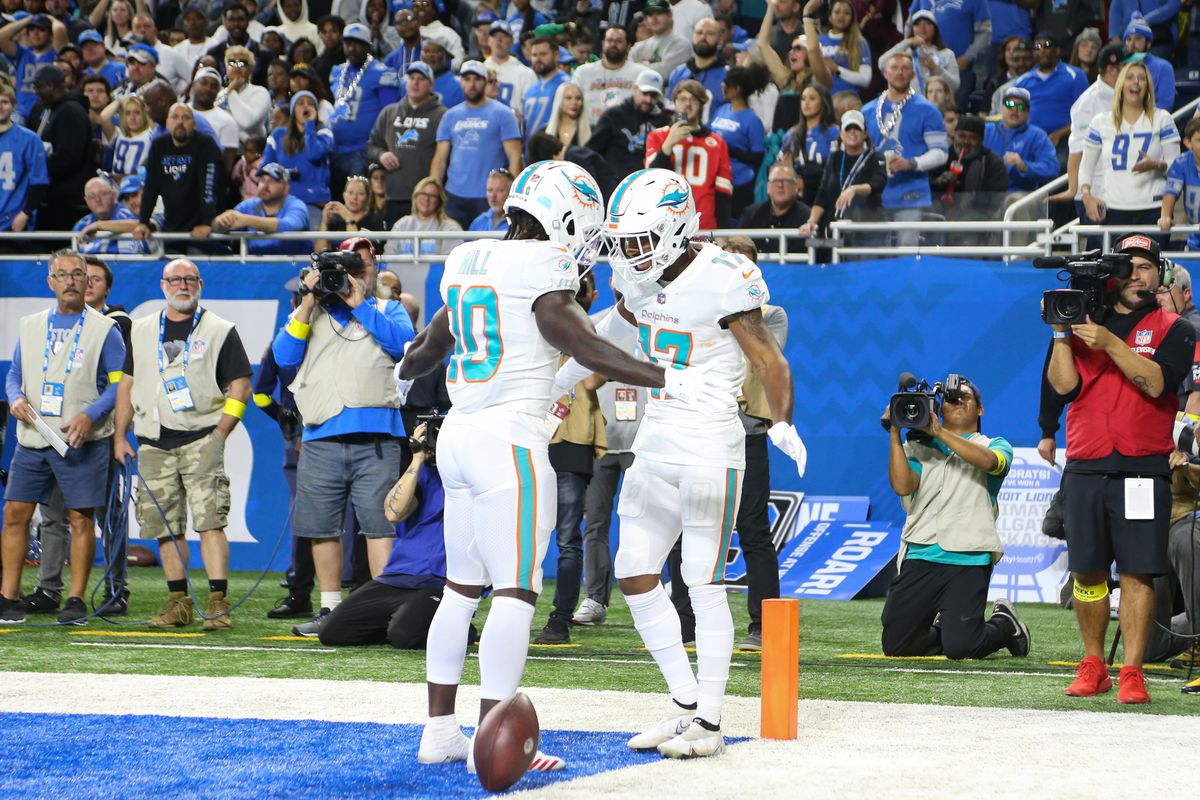 Miami Dolphins wide receiver Jaylen Waddle, right, and Miami Dolphins wide receiver Tyreek Hill, left, celebrate after Waddle caught a pass in the end zone for a touchdown during an NFL football game between the Miami Dolphins and the Detroit Lions on October 30, 2022 at Ford Field in Detroit, Michigan.