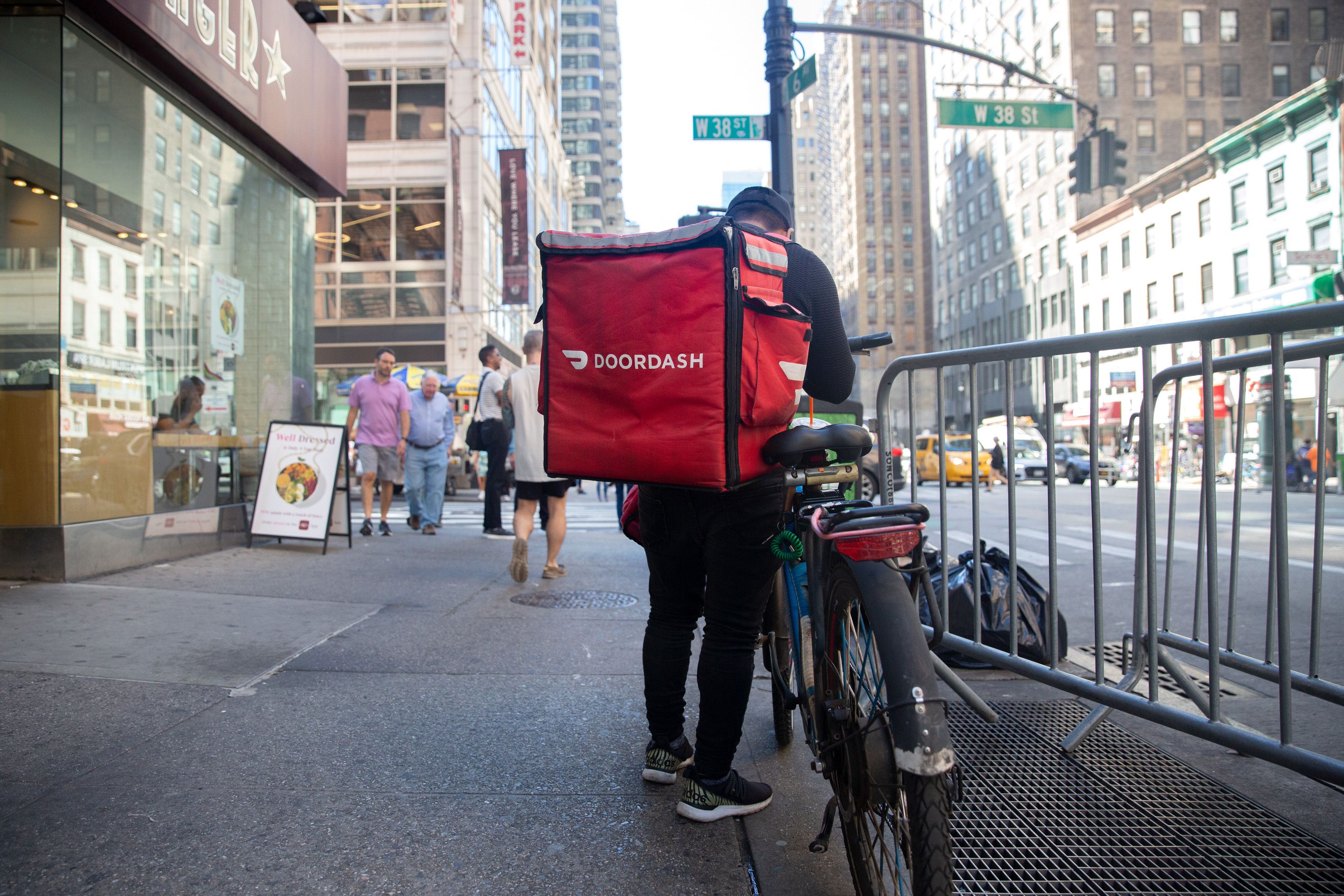 A delivery worker carries a large DoorDash backpack in Midtown.