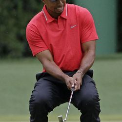 Tiger Woods reacts after missing a putt on the fourth green during the fourth round of the Masters golf tournament Sunday, April 14, 2013, in Augusta, Ga. 