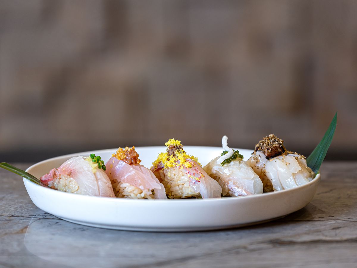 Multiple pieces of nigiri sit on a plate at Sushi by Hidden.