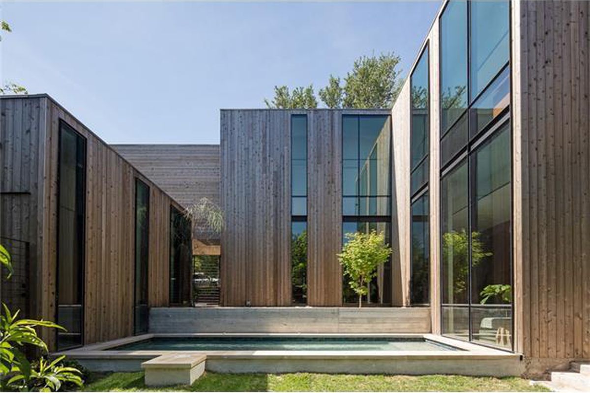 two-story contemporary with blocky design, two-story windows, and slatted wooden facade