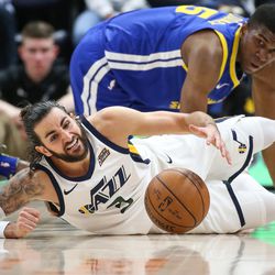 Utah Jazz guard Ricky Rubio (3) dives for a loose ball ahead of Golden State Warriors forward Kevon Looney (5) during the game at Vivint Arena in Salt Lake City on Tuesday, April 10, 2018.