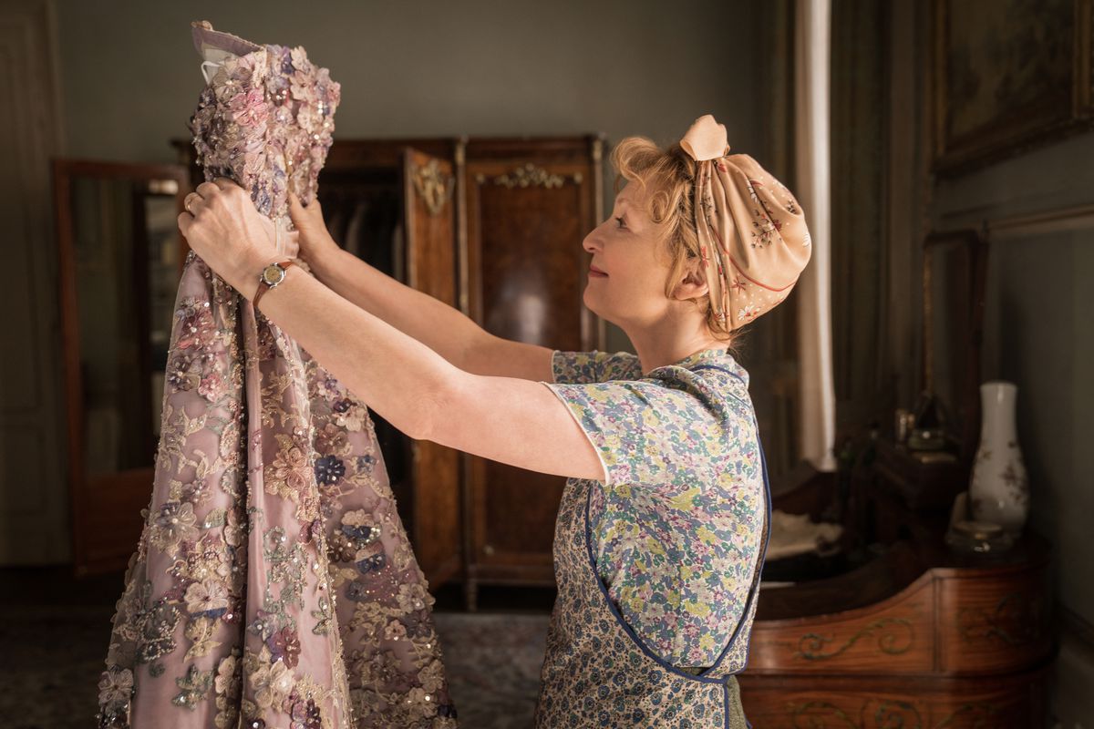 Lesley Manville looks at a dress in Mrs. Harris Goes to Paris.
