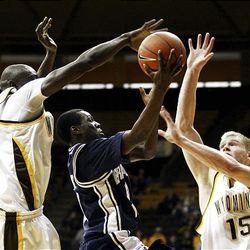 Wyoming teammates Djibril Thiam, left, and Adam Waddell combine to block the shot of BYU guard Michael Loyd Jr. during the Cougars' 22-point win in Laramie on Saturday.