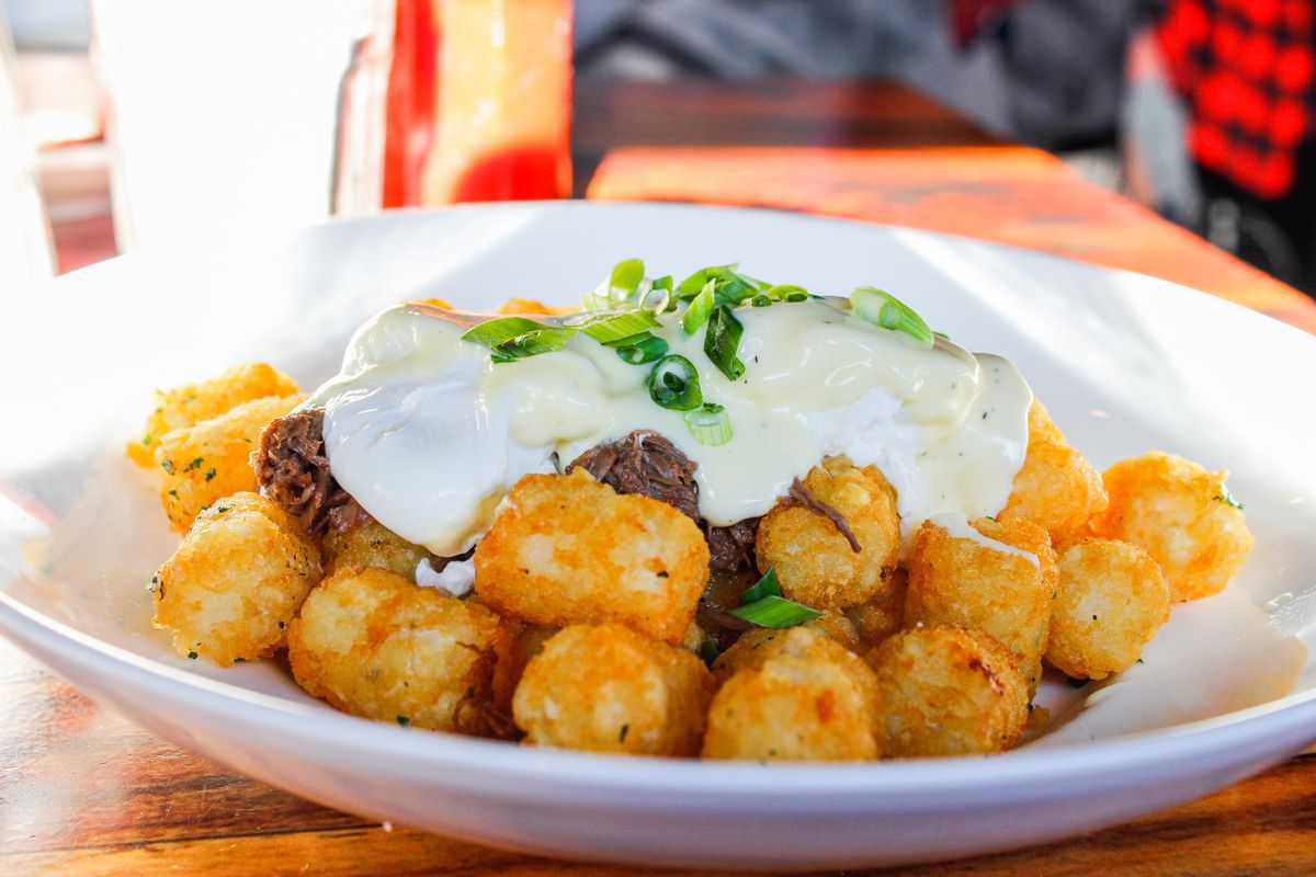 Poached eggs, hollandaise, and braised short ribs served over a pile of tater tots.