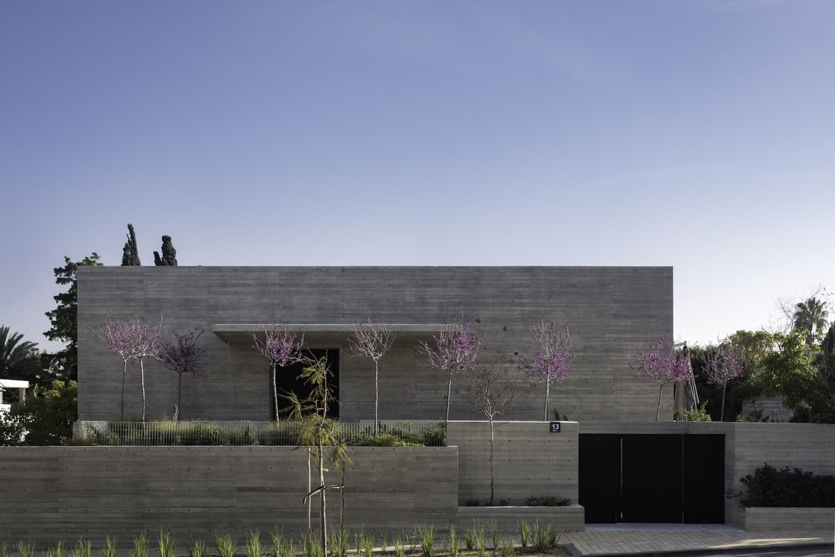 Concrete house with pink trees in front