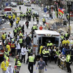 Medical workers aid injured people at the finish line of the 2013 Boston Marathon following an explosion in Boston, Monday, April 15, 2013.  Two explosions shattered the euphoria of the Boston Marathon finish line on Monday, sending authorities out on the course to carry off the injured while the stragglers were rerouted away from the smoking site of the blasts. 