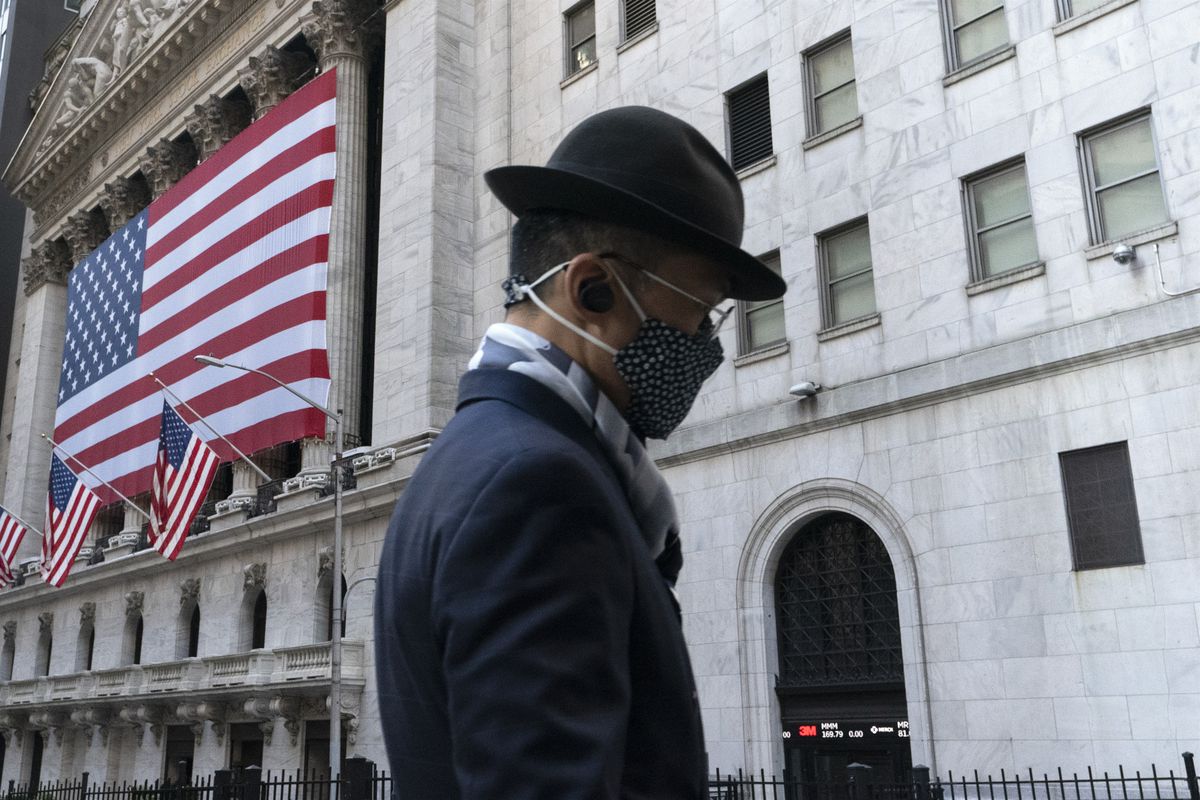 In this Nov. 16, 2020 file photo a man wearing a mask passes the New York Stock Exchange in New York. Stocks are opening lower on Wall Street again as Apple and other Big Tech companies give up more ground. The S&amp;P 500 index fell 1.2% in the early going Tuesday, May 11, 2021. 