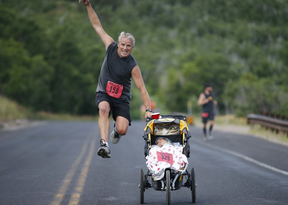 Steve Anderson has some fun with Elisha Stockseth druing the Deseret News Marathon in Emigration Canyon on Monday, July 24, 2017.