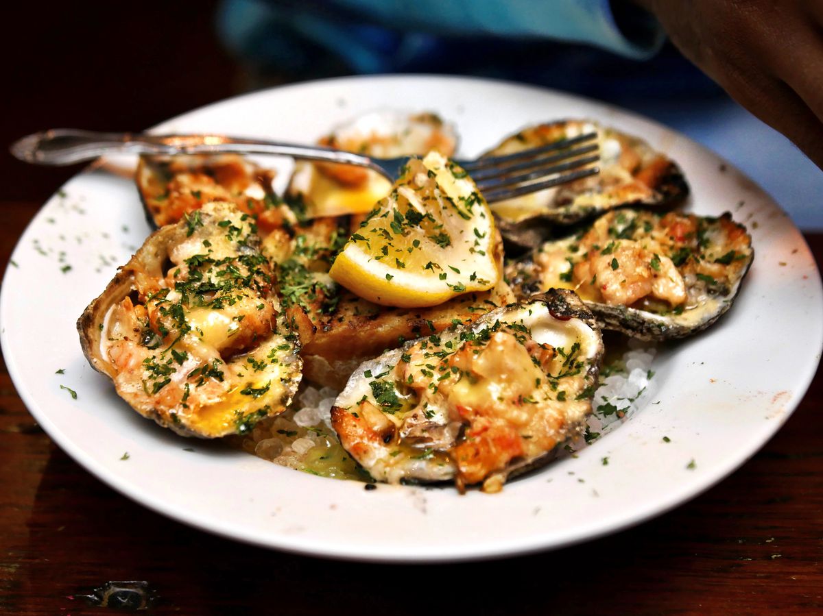 Roast oyster garnished in chives and hot sauce