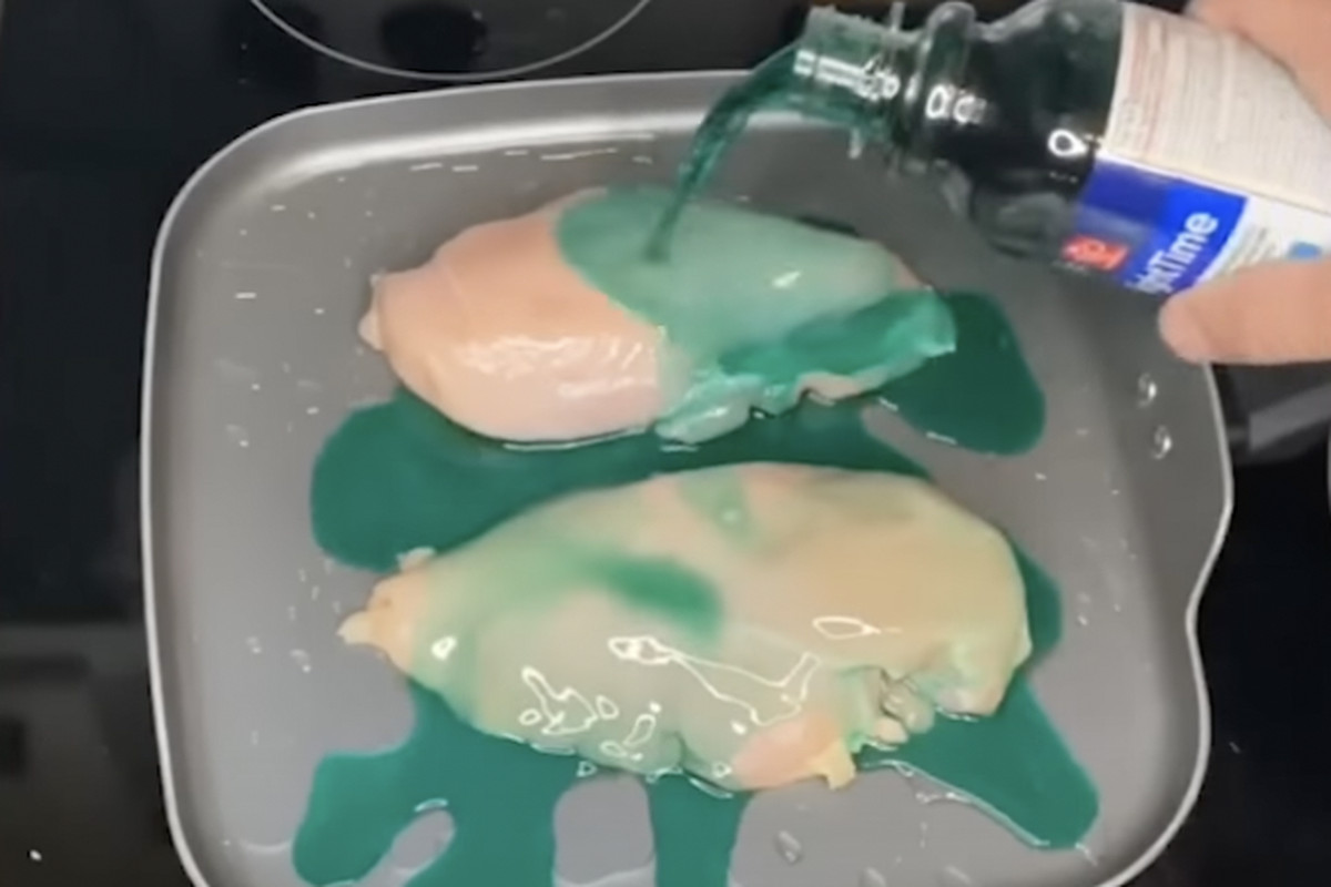a screenshot of a video in which a person pours nyquil onto chicken breast to make “sleepy chicken” 