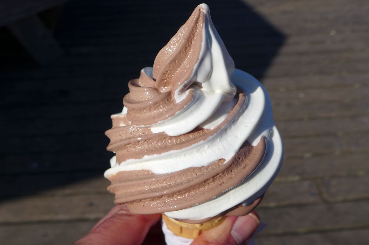 A soft serve cone with swirls of chocolate and vanilla.