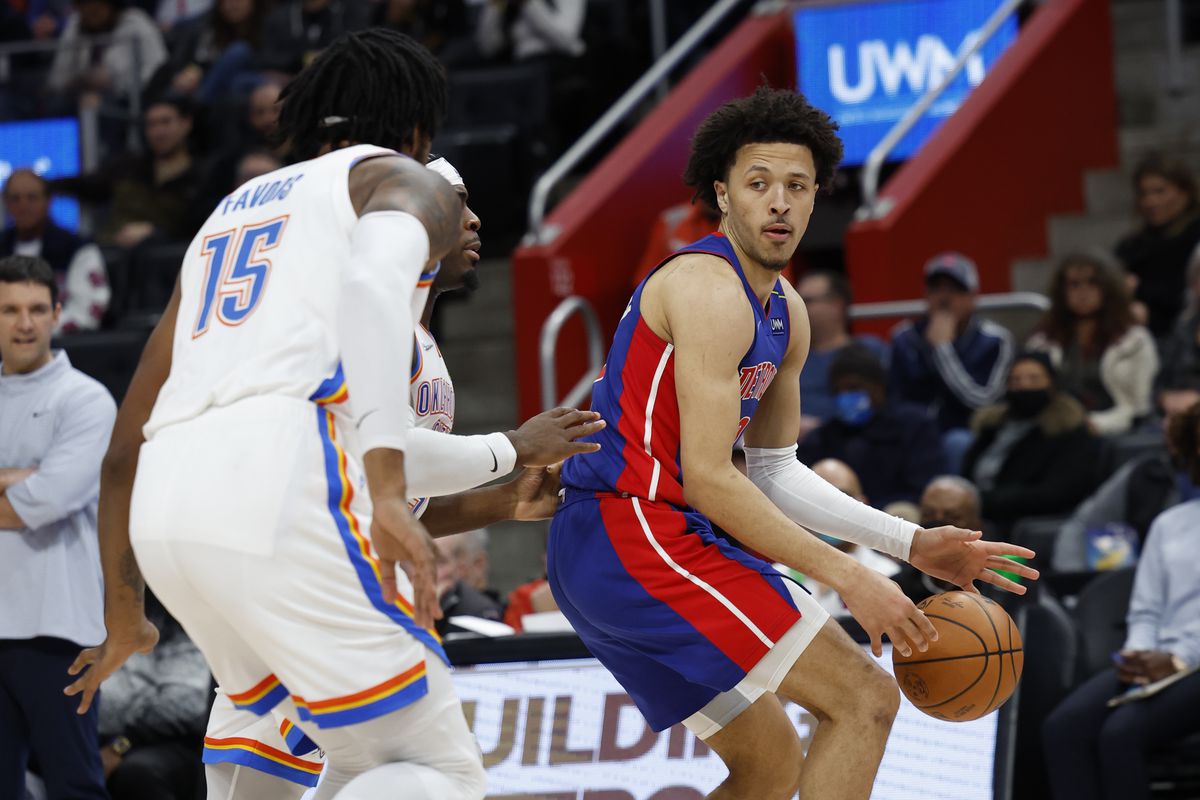 Detroit Pistons guard Cade Cunningham (2) dribbles defended by Oklahoma City Thunder center Derrick Favors (15) in the second half at Little Caesars Arena.