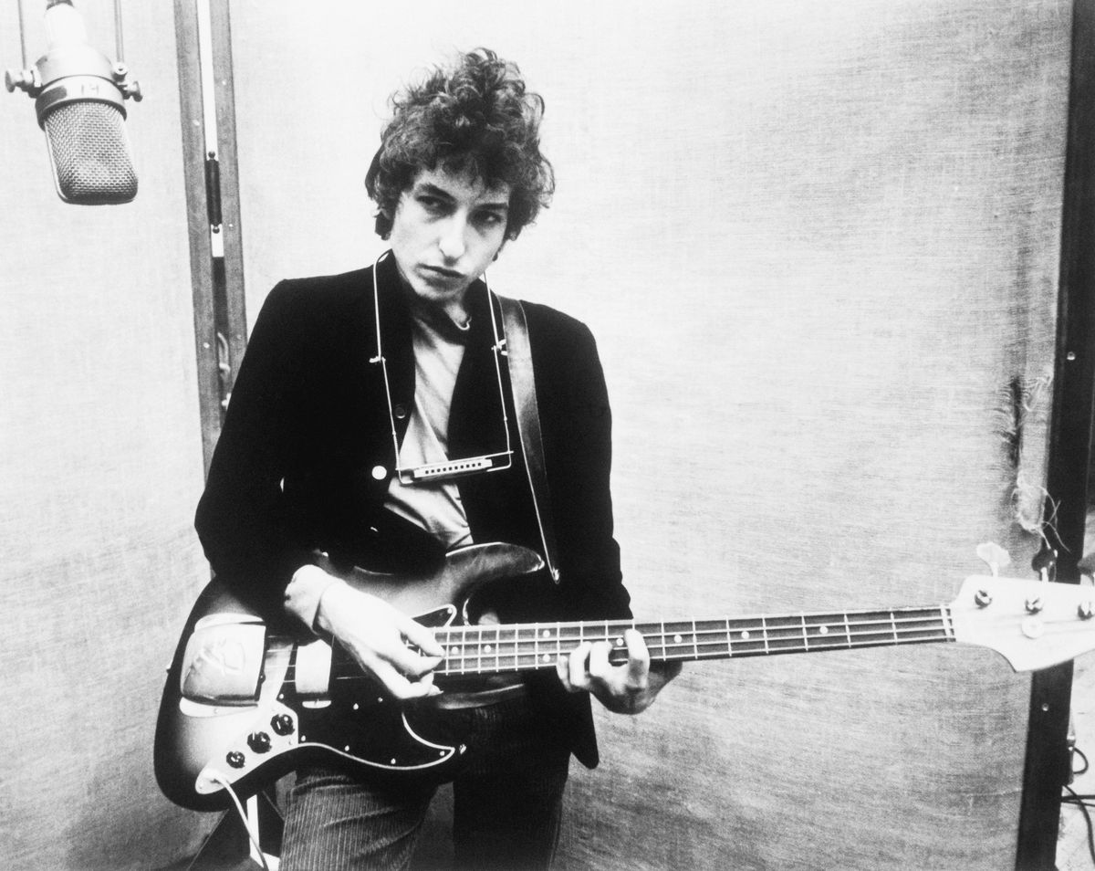 Bob Dylan holding a bass guitar in the late 1960s