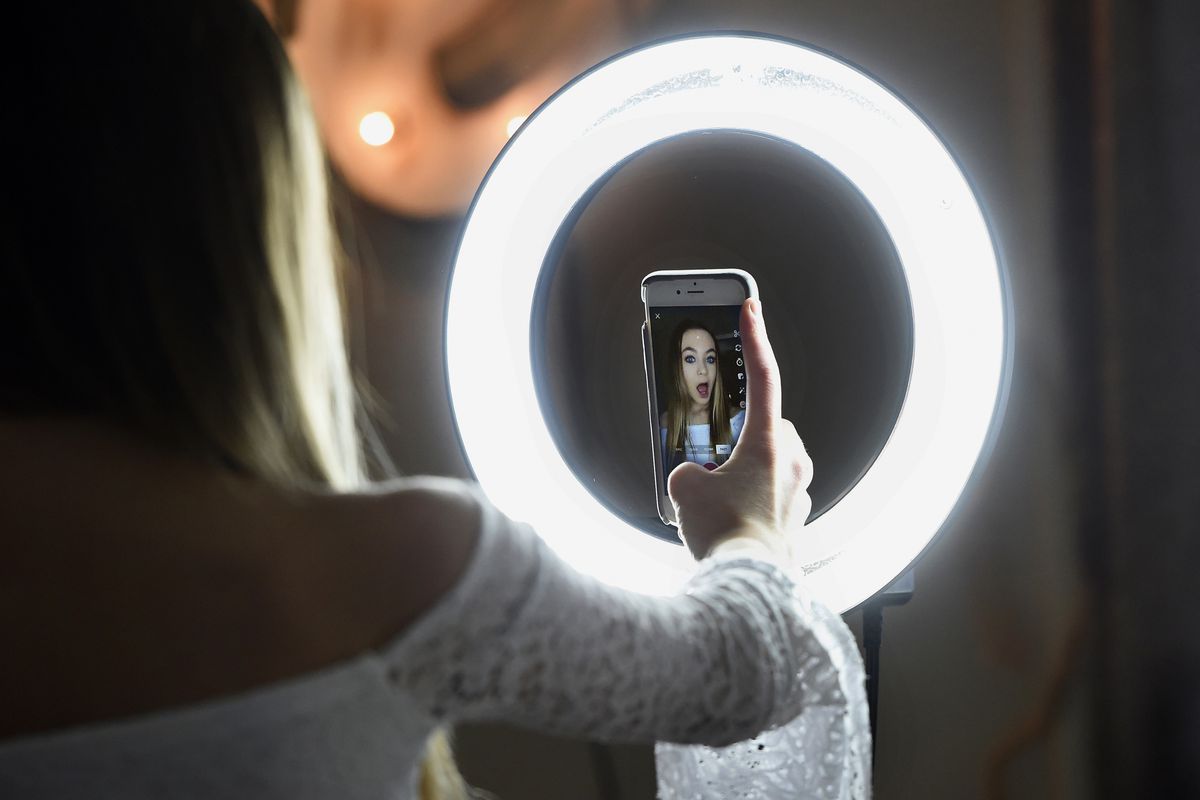 A person using a ring light to take a selfie.