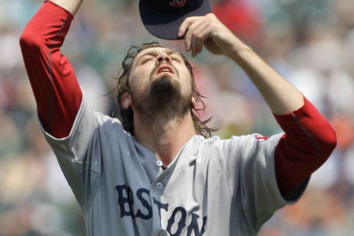 BALTIMORE, MD - JULY 20: Starting pitcher Andrew Miller #30 of the Boston Red Sox looks hungrily at his hat.