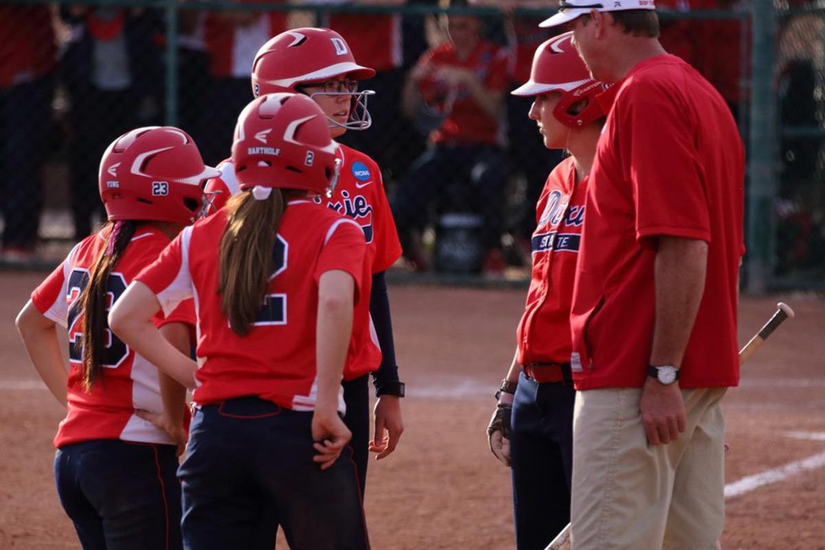 Dixie State softball head coach Randy Simkins (right) talks to his players during a timeout vs. Western Washington on Feb. 13. The Red Storm are on the road in Northern California for eight games in five days.