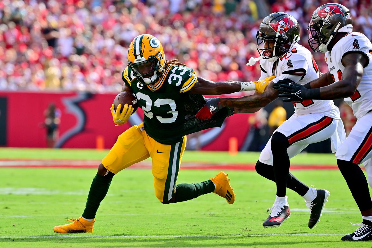 Aaron Jones of the Green Bay Packers runs the ball against Carlton Davis III of the Tampa Bay Buccaneers during the first quarter in the game at Raymond James Stadium on September 25, 2022 in Tampa, Florida.