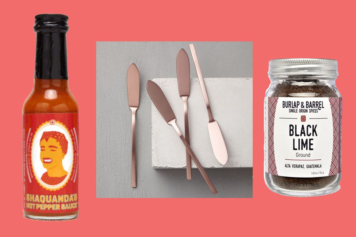 hot sauce, rose gold cheese knives and spice jar on pink background