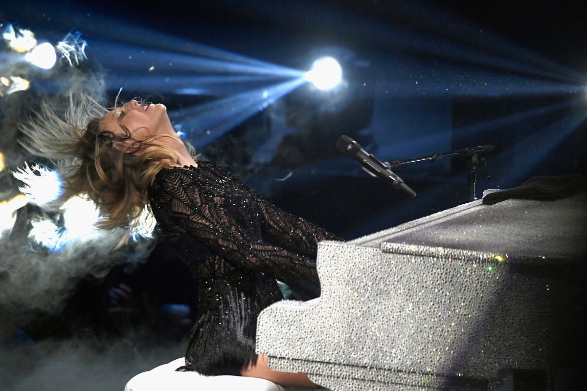 Taylor Swift performing seated at a silver piano in Houston, Texas in February 2017