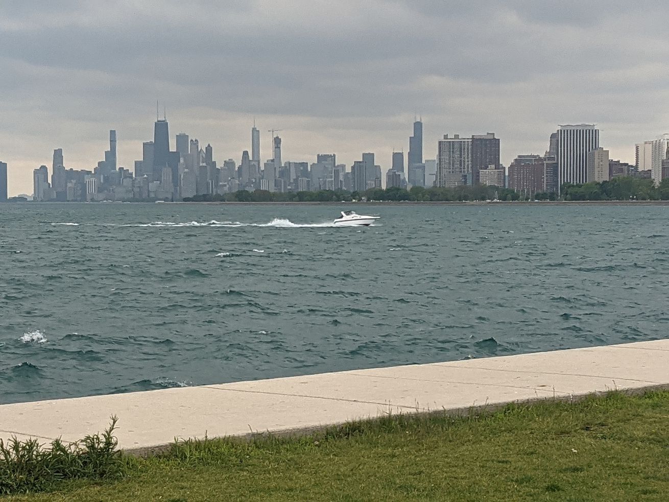 A boat speeds back toward Montrose Harbor in the middle of the best view of downtown Chicago from the south side of Montrose, the day before parking meters turned on at Montrose Harbor Drive. Credit: Dale Bowman