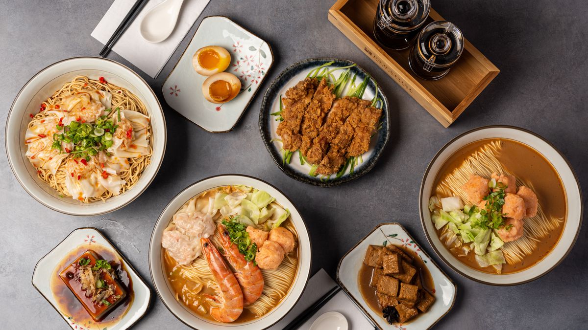 An overhead shot of a table filled with Japanese food, including ramen.