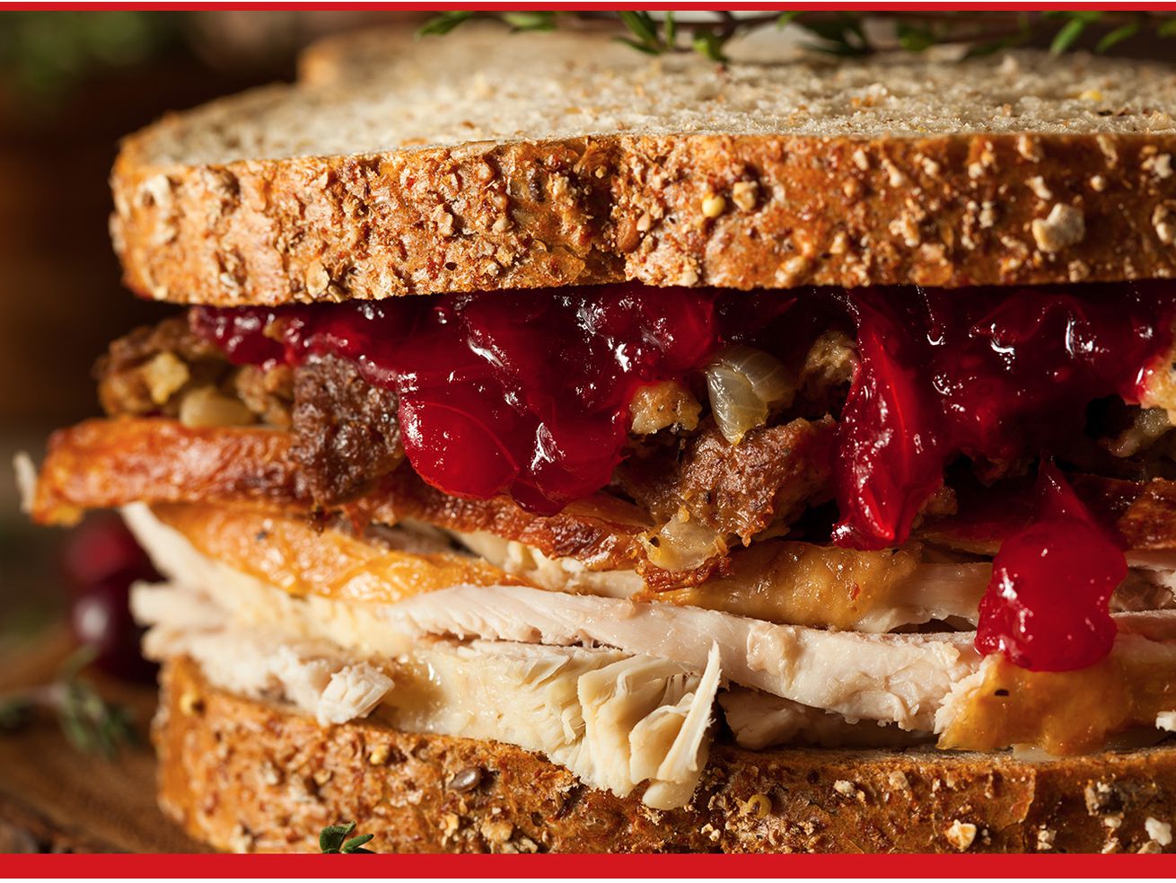 Sandwich with turkey, cranberry sauce, and stuffing in between two slices of bread.