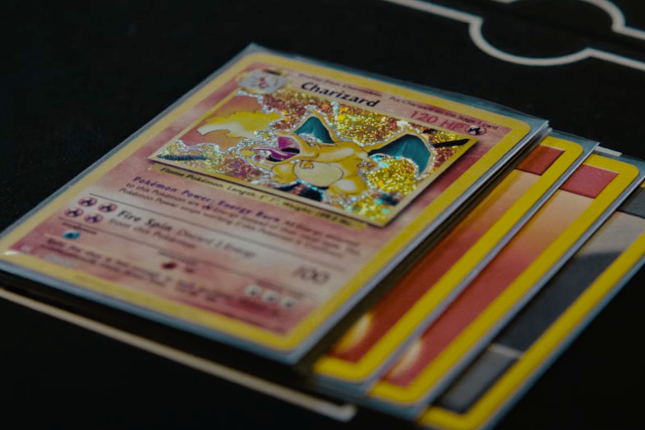 A closeup of a Charizard card and three energy cards stacked beneath it.