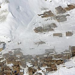 An Afghan national army helicopter delivers emergency items after an avalanche in the Paryan district of Panjshir province, north of Kabul, Afghanistan, Friday, Feb. 27, 2015. The death toll from severe weather that caused avalanches and flooding across much of Afghanistan has jumped to more than 200 people, and the number is expected to climb with cold weather and difficult conditions hampering rescue efforts, relief workers and U.N. officials said Friday. 