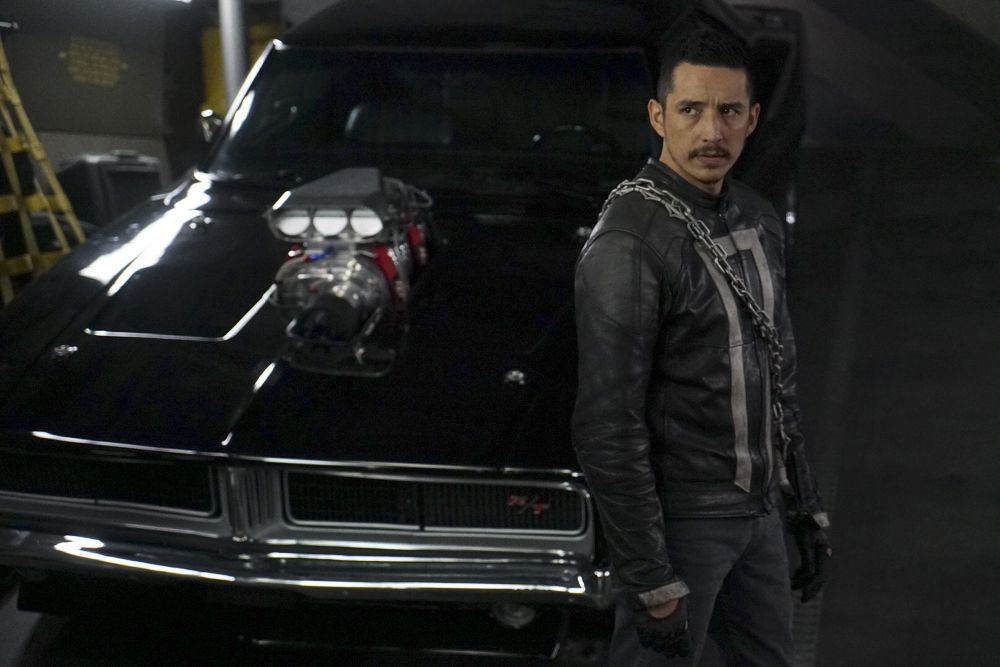 Gabriel Luna wears all black as the Ghost Rider in front of his black car in Agents of SHIELD.