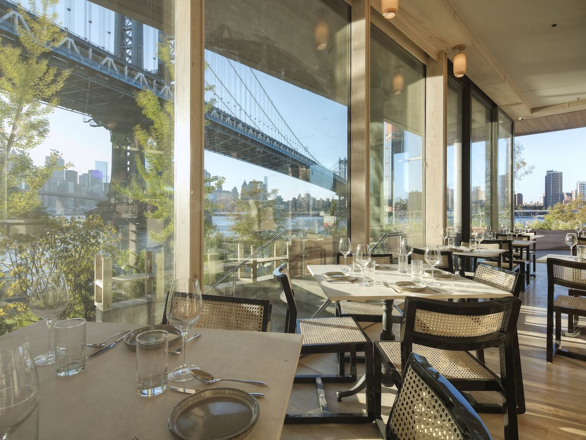 A restaurant dining with large windows and a view of the Manhattan Bridge.