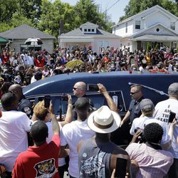 The hearse carrying the body of Muhammad Ali passes in front of his boyhood home, top center, during his funeral procession Friday, June 10, 2016, in Louisville, Ky. 
