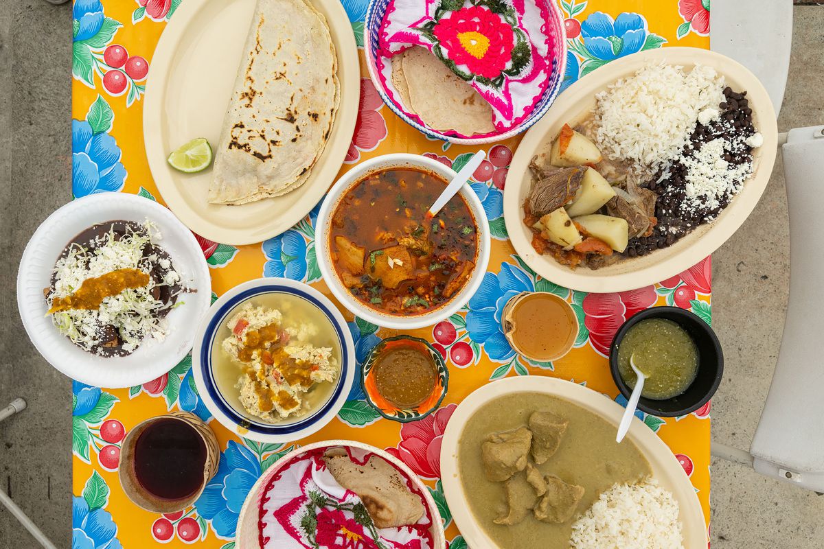 Traditional Oaxacan dishes are laid out on a colorful table at Comedor Tenchita.